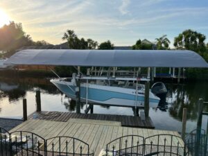 Boat hoist canopy covers protecting a boat from Florida's harsh weather conditions, including strong winds and intense sun.